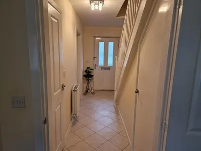 a hallway with a hallway leading to a room with a door at Lovely and Cosy Double Room in Havering atte Bower