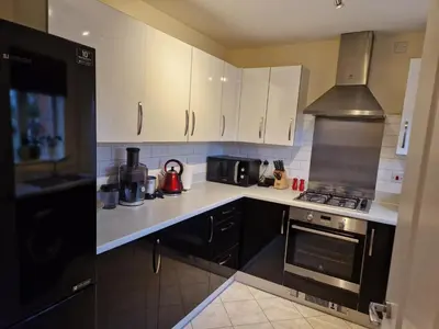 a kitchen with white cabinets and a stove top oven at Lovely and Cosy Double Room in Havering atte Bower