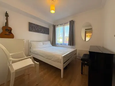 a bedroom with a bed and a chair and a mirror at The Tetris Retreat in Cambridge