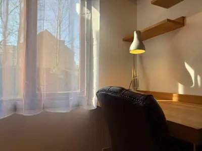 a chair sitting in front of a window with a lamp at The Tetris Retreat in Cambridge