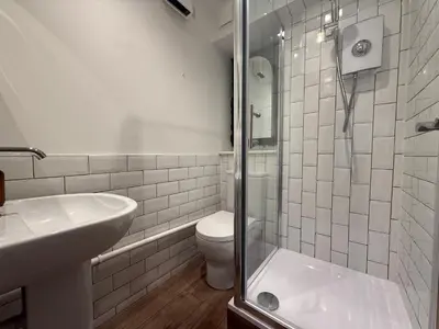 a bathroom with a shower and a toilet and a sink at The Tetris Retreat in Cambridge