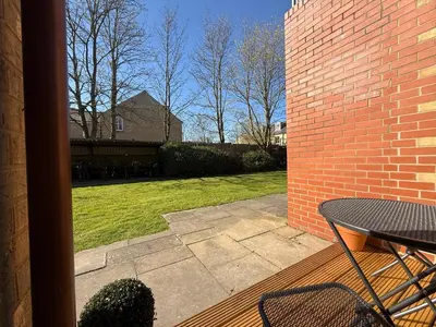 a patio with a table and a brick wall at The Tetris Retreat in Cambridge