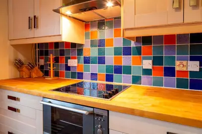 a kitchen with colorful tiles on the wall at Pass the Keys Spacious Modern Home near River Cam Free Parking in Cambridge