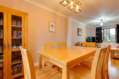 a dining room with a wooden table and chairs at Pass the Keys Spacious Modern Home near River Cam Free Parking in Cambridge
