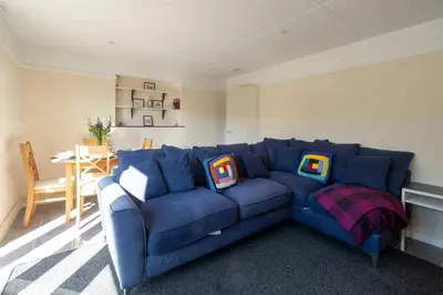 a blue couch with pillows on it in a living room at 6 Franklin Rd - Aldeburgh Coastal Cottages in Aldeburgh