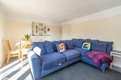 a blue couch with pillows on it in a living room at 6 Franklin Rd - Aldeburgh Coastal Cottages in Aldeburgh