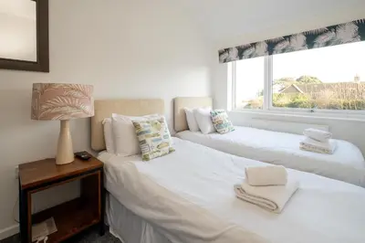 two white beds in a room with a window at 51 The Plantation - Aldeburgh Coastal Cottages in Aldeburgh