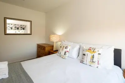 a bedroom with a bed with white sheets and pillows at 51 The Plantation - Aldeburgh Coastal Cottages in Aldeburgh