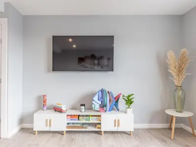 a white cabinet with books on it in a room at 4-Bedroom Seafront House in Southend Sea Views - Pass the Keys in Southend-on-Sea