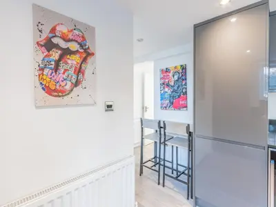 a hallway with a staircase and a painting on the wall at 4-Bedroom Seafront House in Southend Sea Views - Pass the Keys in Southend-on-Sea