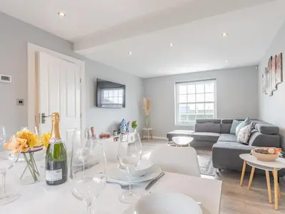 a living room with a table with wine glasses at 4-Bedroom Seafront House in Southend Sea Views - Pass the Keys in Southend-on-Sea