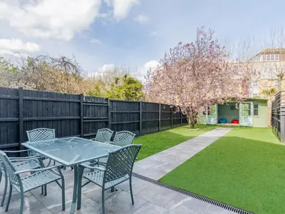 a patio with a table and chairs and a fence at 4-Bedroom Seafront House in Southend Sea Views - Pass the Keys in Southend-on-Sea