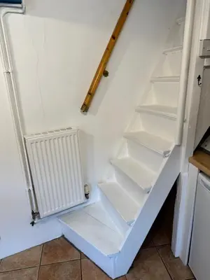 a white refrigerator with empty shelves in a kitchen at Cosy Little Cottage in Woodbridge
