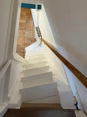 a stairwell with white stairs and a tile floor at Cosy Little Cottage in Woodbridge