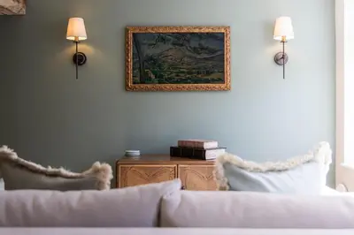 a living room with a couch and a picture on the wall at Ruperts Cottage in Coggeshall