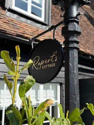 a sign on a pole in front of a building at Ruperts Cottage in Coggeshall