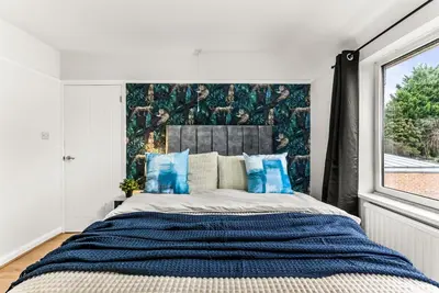a bedroom with a large bed with blue pillows at Gorgeous Abode in Cambridge - Pet Friendly! in Cherry Hinton