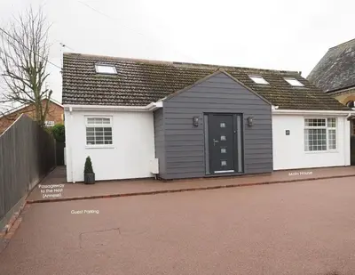 a house with a black and white garage at The Nest in Needingworth