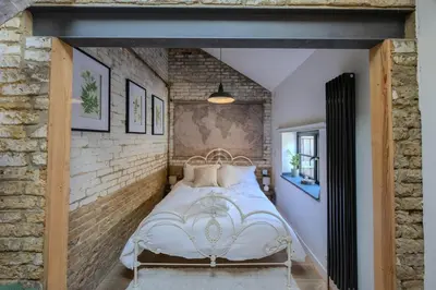 a bedroom with a bed in a brick wall at The Stables in Southend-on-Sea