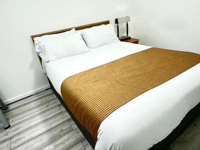 a bedroom with a large bed with white and brown blanket at Modern Stylish 4Bed 2 Bath in Pitsea, Basildon Essex 2 Free Carpark in Nevendon