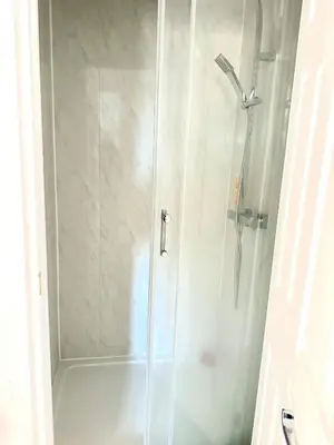 a shower with a glass door in a bathroom at Modern Stylish 4Bed 2 Bath in Pitsea, Basildon Essex 2 Free Carpark in Nevendon