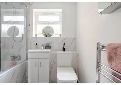 a white bathroom with a sink and a mirror at The Barack Nest Colchester in Colchester