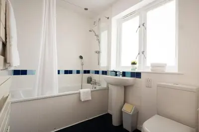 a white bathroom with a sink and a tub and a toilet at Stylish 3-Bedroom Detached Home in Cambridge in Chesterton