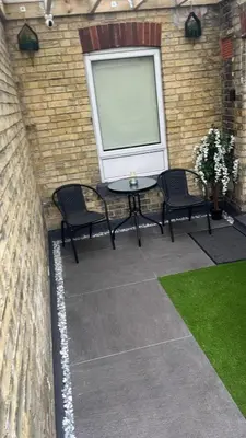 a patio with two chairs and a table in front of a building at Brandon Apartment in Town Centre with parking in Brandon