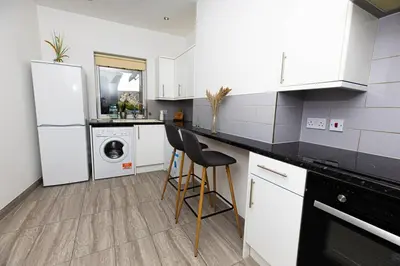 a kitchen with a white refrigerator and a dishwasher at Brandon Apartment in Town Centre with parking in Brandon