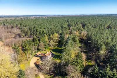 an aerial view of a house in the woods at Marvellous secluded forest lodge - Stone Hall in Eyke