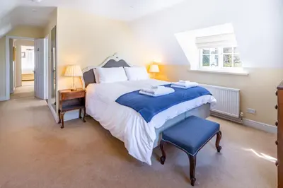 a bedroom with a large bed and a chair at Marvellous secluded forest lodge - Stone Hall in Eyke