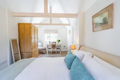a bedroom with a bed and a table at Marvellous secluded forest lodge - Stone Hall in Eyke