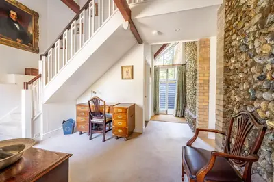 an attic room with a stone wall and a desk and chair at Marvellous secluded forest lodge - Stone Hall in Eyke
