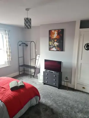 a bedroom with a red bed and a television at The Harwich Hideaway in Harwich