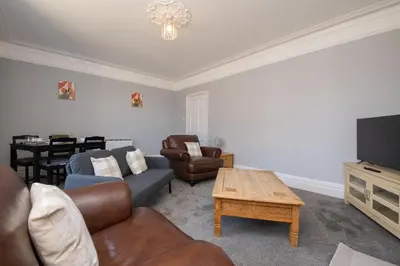 a living room with a couch and chairs and a tv at The Harwich Hideaway in Harwich