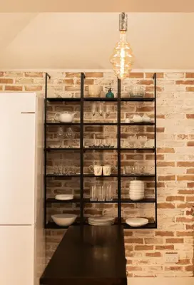 a kitchen with a black table and a shelf with dishes at Bright Mews House with Garage in Heart of Cambridge in Cambridge