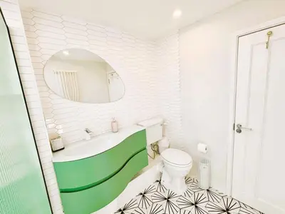 a bathroom with a sink and a toilet and a mirror at Bright Mews House with Garage in Heart of Cambridge in Cambridge