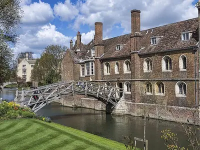 a bridge over a river in front of a building at Bright Mews House with Garage in Heart of Cambridge in Cambridge