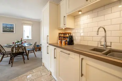 a kitchen with a sink and a table at 3 St Johns Court - Aldeburgh Coastal Cottages in Aldeburgh