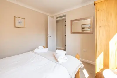 a bedroom with two beds and a mirror at 3 St Johns Court - Aldeburgh Coastal Cottages in Aldeburgh