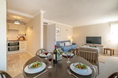 a dining room and living room with a table and chairs at 3 St Johns Court - Aldeburgh Coastal Cottages in Aldeburgh