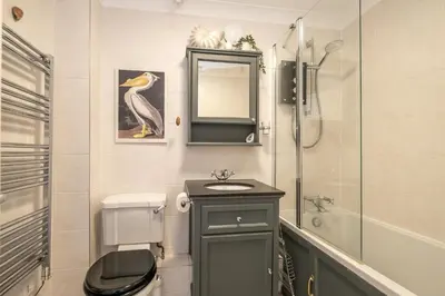 a bathroom with a sink and a toilet and a shower at 3 St Johns Court - Aldeburgh Coastal Cottages in Aldeburgh