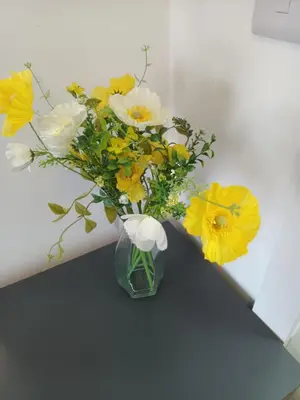 a vase filled with yellow and white flowers on a table at Central en-suite room, WIFI, Kitchen and Laundry Access - room 5 in Ipswich