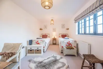 a bedroom with two twin beds and a window at 8 Oaks Court, Thorpeness in Thorpeness