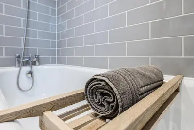 a towel sitting on a bath tub in a bathroom at 8 Oaks Court, Thorpeness in Thorpeness