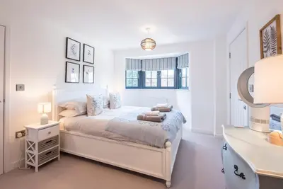 a white bedroom with a bed and a desk at 8 Oaks Court, Thorpeness in Thorpeness