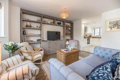 a living room with a couch and a tv at 8 Oaks Court, Thorpeness in Thorpeness
