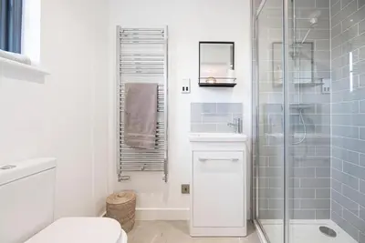 a bathroom with a shower and a toilet and a sink at 8 Oaks Court, Thorpeness in Thorpeness