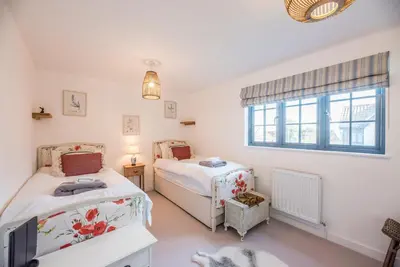 a bedroom with two beds and a window at 8 Oaks Court, Thorpeness in Thorpeness