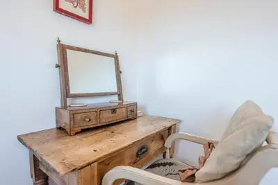 a dressing table with a mirror and a chair at 8 Oaks Court, Thorpeness in Thorpeness